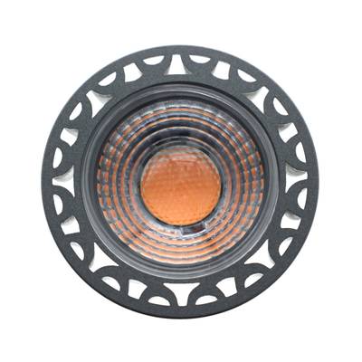 Gros plan sur une ampoule LED ronde, dotée d'un bord noir texturé et d'une partie centrale orange. Luminaire de décoration moderne.