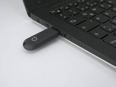 Clé USB connectée à un ordinateur portable sur fond blanc, symbolisant la connectivité et la technologie dans les solutions d'éclairage LED modernes.