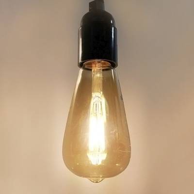 Lampe LED vintage avec base noire, suspendue sur un fond uni - parfaite pour les solutions d'éclairage rétro et à faible consommation d'énergie.
