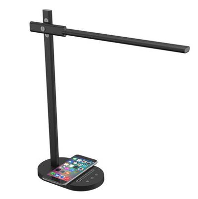 Lampe de table LED noire moderne, commandes tactiles sur une base ronde, smartphone placé sur la base de la lampe.