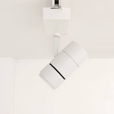 Un luminaire blanc moderne illumine un plafond blanc et met en valeur l'intérieur de votre maison. Éclairage LED économe en énergie pour des designs élégants et contemporains.