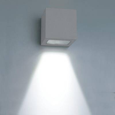 L'applique murale LED en forme de cube émet un faisceau lumineux vers le bas sur un mur bleu doux et met en valeur les intérieurs modernes grâce à un éclairage économe en énergie.