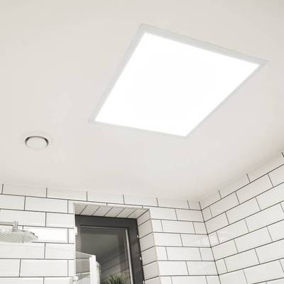 Panneau lumineux à LED monté sur un plafond de salle de bain carrelé blanc avec fenêtre et ventilateur, fournissant un éclairage économe en énergie.