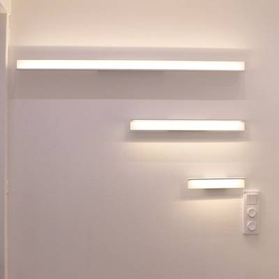 Appliques horizontales minimalistes de différentes longueurs pour un mur simple avec un panneau d'interrupteur en dessous. Éclairage LED moderne dans un magasin.
