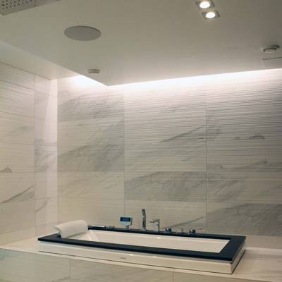 Salle de bains moderne avec carreaux de marbre, baignoire rectangulaire et plafonniers LED encastrés