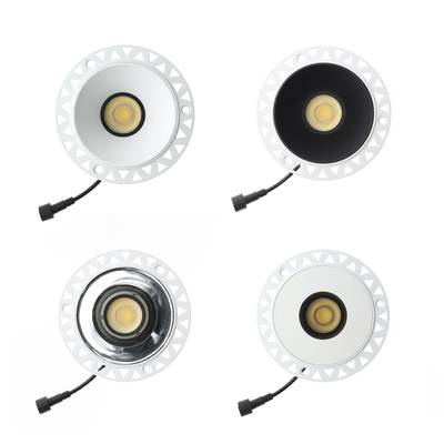 "Un ensemble de quatre lumières LED rondes avec des bords blancs, des intérieurs contrastés noirs et blancs et de courts câbles de connexion noirs.