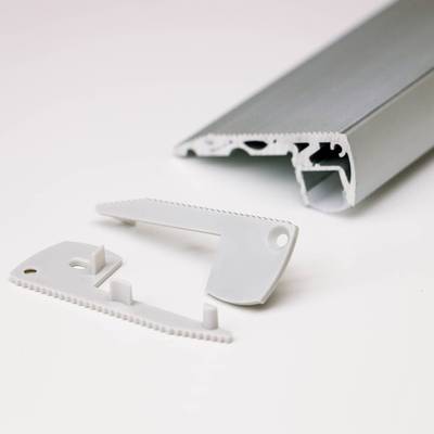 Gros plan sur des composants d'éclairage LED démontés : rail métallique gris et pièces en plastique blanc avec un bord denté. Lampes LED de haute qualité à vendre.
