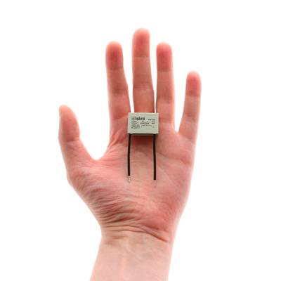 Gros plan d'une main avec une diode LED à deux broches, idéale pour les solutions d'éclairage à faible consommation d'énergie, sur fond blanc.