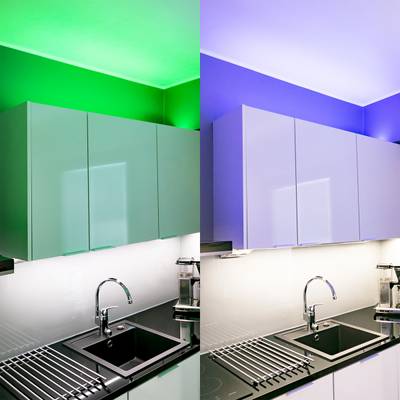 Cuisine moderne avec des armoires et un évier de style, éclairée par des LED vertes d'un côté et bleues de l'autre.