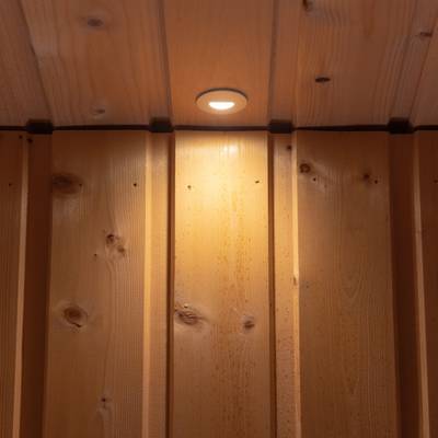 Un plafond en bois naturel et chaleureux avec un éclairage LED encastré et des panneaux verticaux pour une atmosphère chaleureuse.