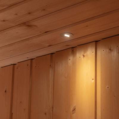Un luminaire LED monté au plafond éclaire les panneaux muraux en bois situés en dessous.