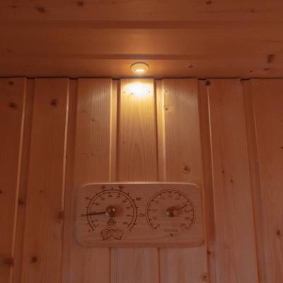Présentoir mural en bois avec petite lampe éclairée par LED et carrelage en bois avec thermomètre et hygromètre intégrés pour une atmosphère domestique moderne.