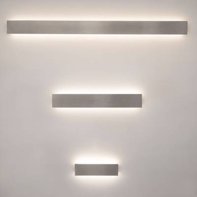 Trois luminaires LED rectangulaires et verticaux qui diffusent une lumière chaude sur un mur pâle ; idéal pour les solutions d'éclairage domestique modernes.