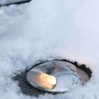Un lampadaire LED d'extérieur encastré dans un paysage enneigé, éclairant doucement les chemins, les jardins et les espaces extérieurs.