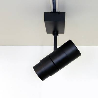 Luminaire cylindrique noir sur rail monté sur un plafond blanc pour des solutions d'éclairage LED modernes.