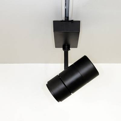 Luminaire sur rail cylindrique noir avec toit blanc, orienté vers le bas pour un éclairage ciblé. Idéal pour les intérieurs modernes et les solutions d'éclairage LED à faible consommation d'énergie.
