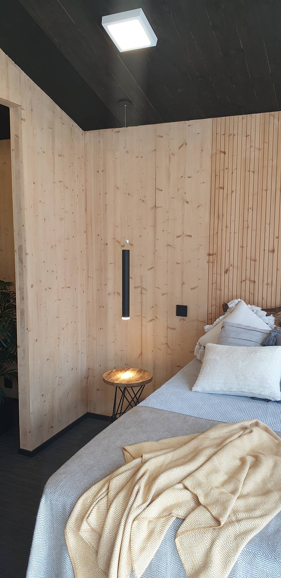 Dans la chambre à coucher, une lampe à suspension sert de liseuse à côté du lit. Ledstore.fi