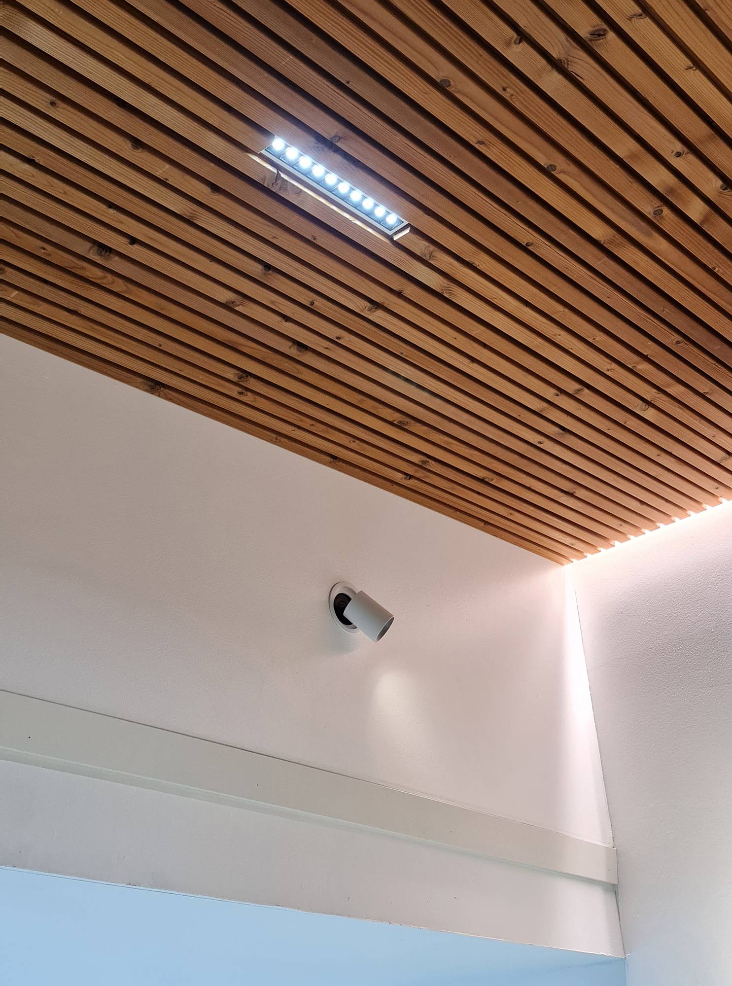 Lumière indirecte sur les bords de la corniche et projecteur LINJA 10 pour créer un éclairage général. Les luminaires LINJA 10 ont un angle d\'éclairage très étroit, ce qui les rend idéaux pour les hauts plafonds. Spot directionnel KOLO encastré dans le mur pour l\'éclairage d\'accentuation d\'un tableau. Ledstore.fi