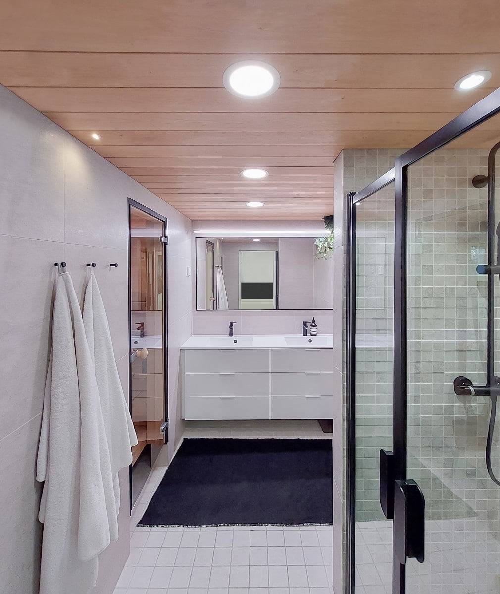 Éclairage polyvalent dans la salle de bains. Plafonds plus larges pour l'éclairage général, bande LED montée sur fils au-dessus du miroir, spot dans la niche de la douche. ©LedStore