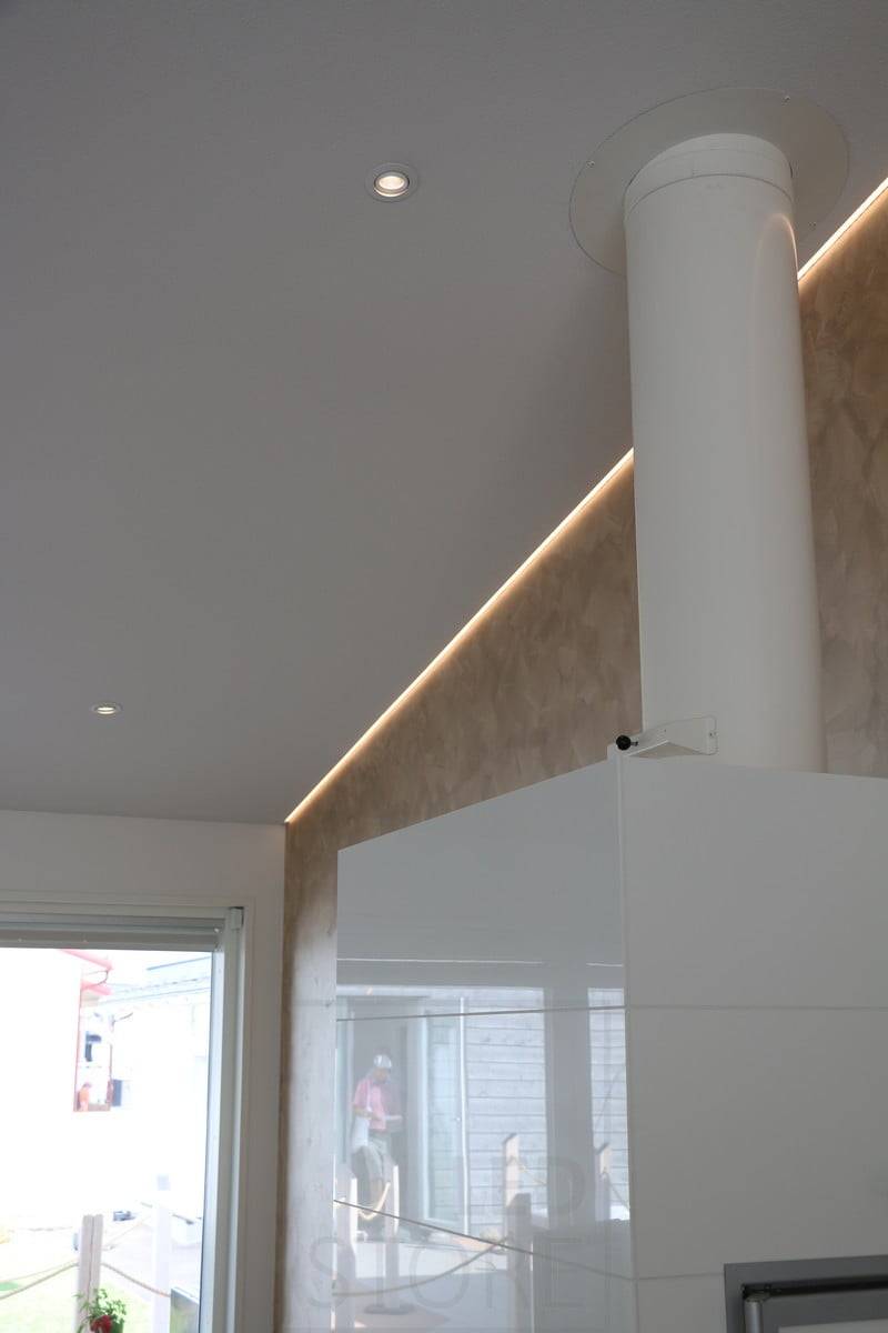 Salon de l'habitat 2018 : profilé led sur un plafond incliné, ascendant, à l'interface mur/plafond, derrière la cheminée. Ledstore.fi