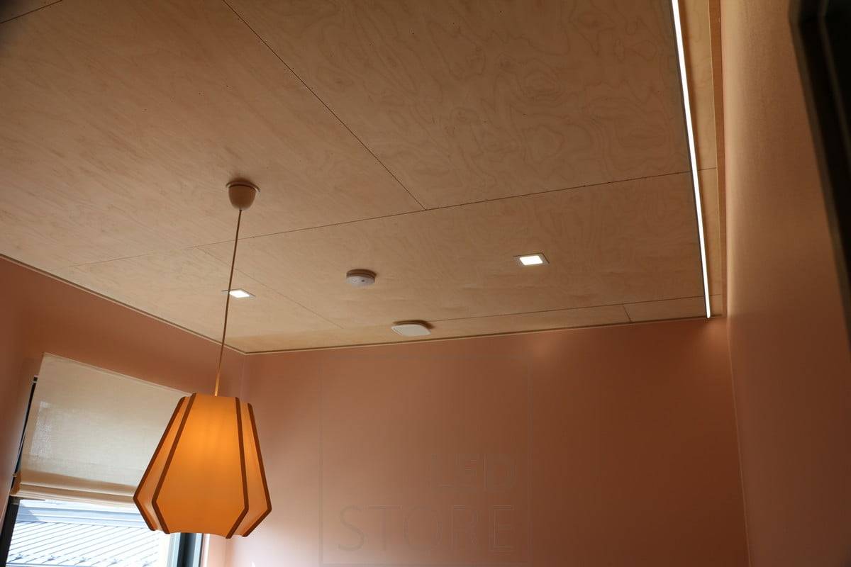 Salon du logement 2019 : Petits panneaux lumineux sur un toit en contreplaqué. Bande de leds éclairant le mur pour une lumière indirecte. Ledstore.fi
