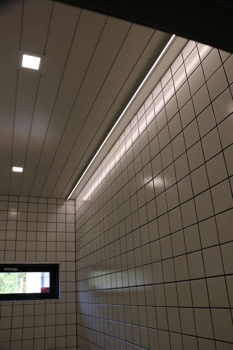 Salon du logement 2019 : Bande LED au plafond à côté du mur, lumière reflétée par le carrelage brillant. Ledstore.fi