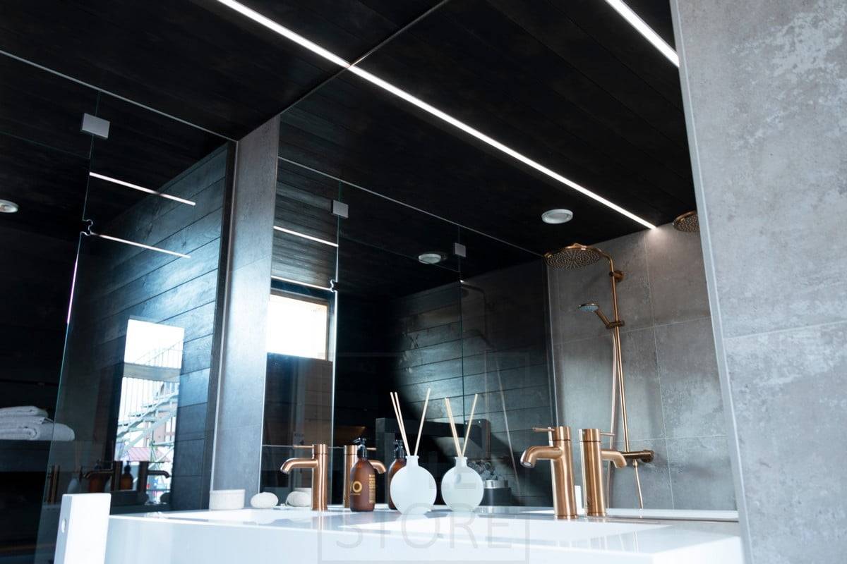 Salon de l'habitat 2020 : bandes de LED éclairant la salle de bain dans des profils encastrés étroits dans le plafond noir de la salle de bain. Ledstore.fi