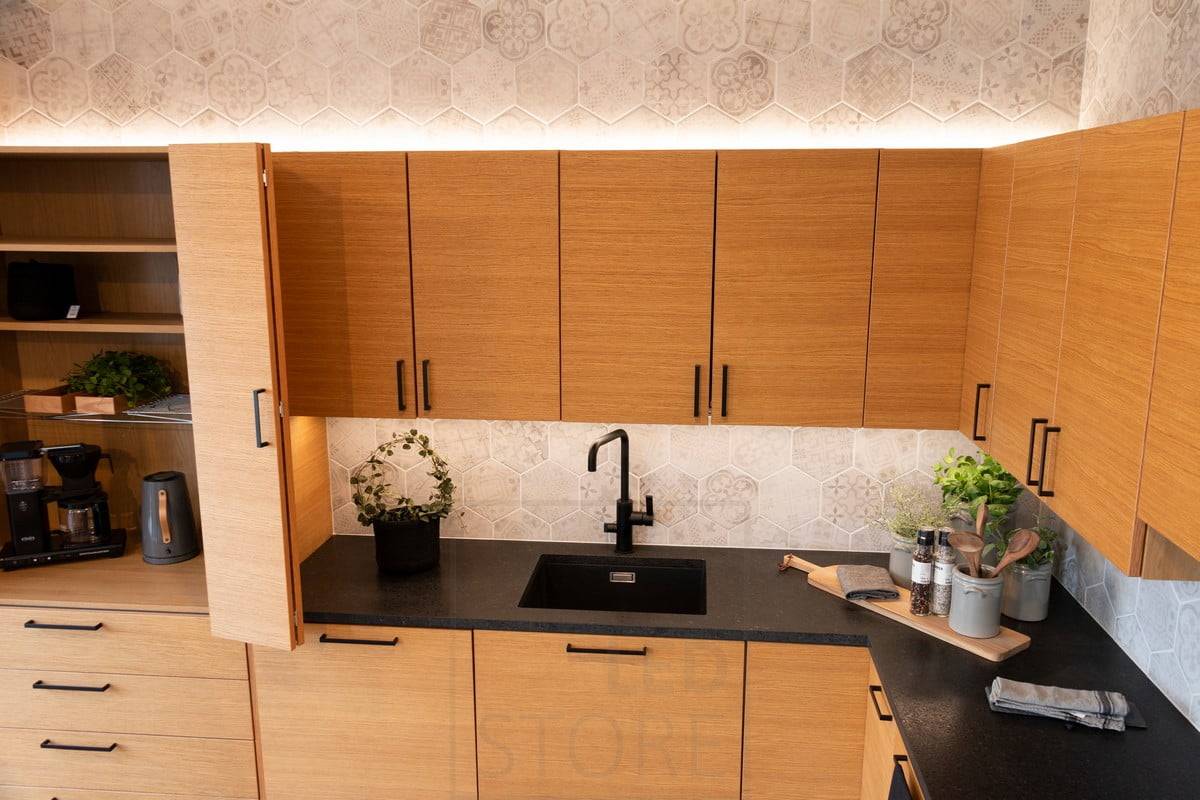 Housing Fair 2020 : lumières indirectes au-dessus des armoires de cuisine et éclairage du plan de travail dans la cuisine en chêne. Ledstore.fi