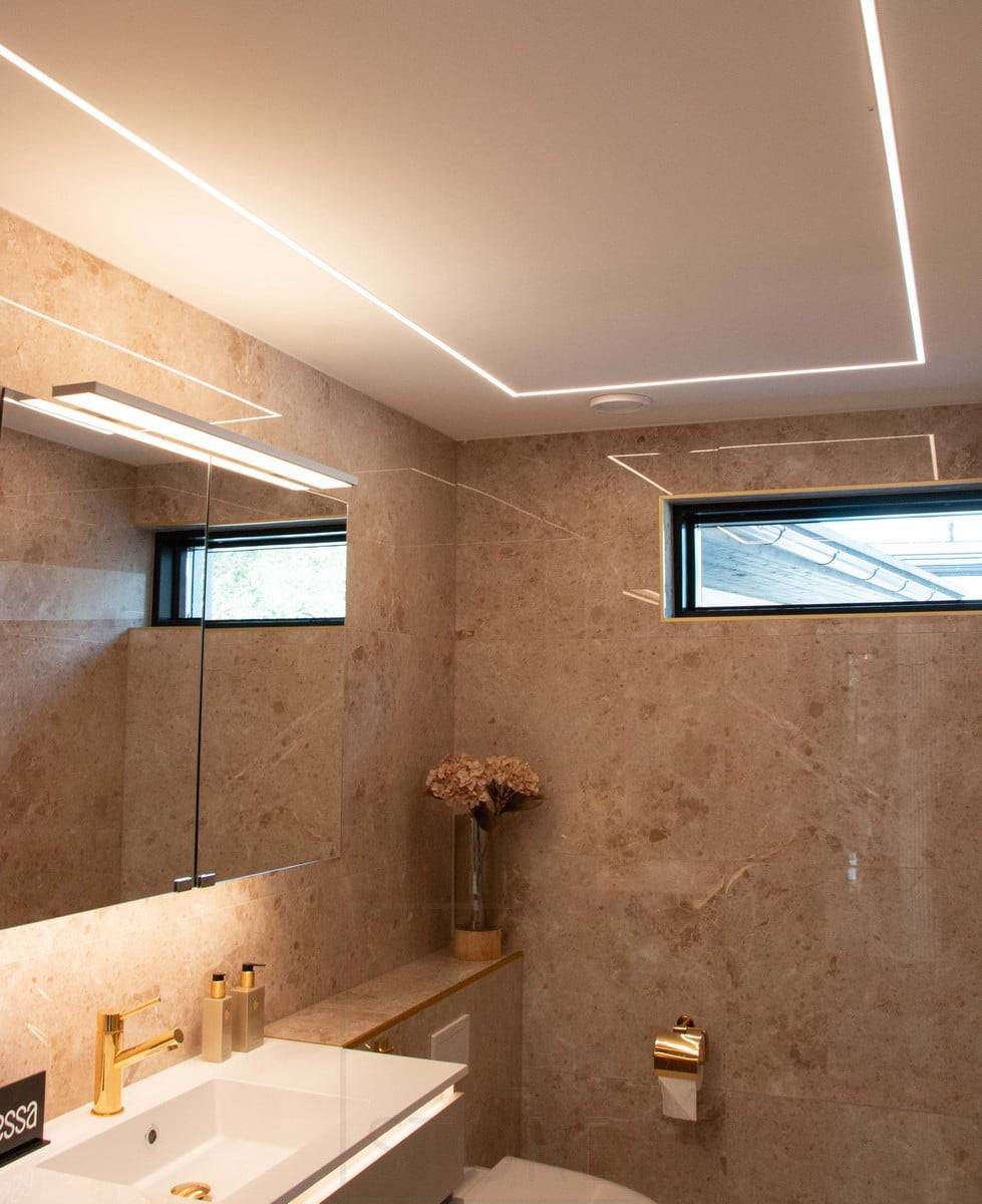 Salon du logement 2022 : profilé étroit de leds encastré dans le plafond en plâtre d'une salle de bains. Ledstore.fi