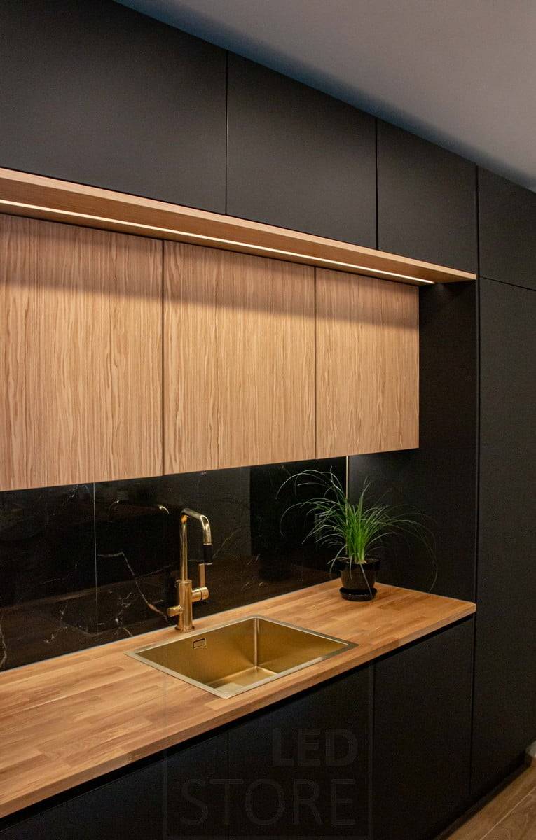 Housing Fair 2022 : Armoires supérieures de cuisine sur deux niveaux, les deux niveaux étant éclairés par des bandes LED. Ledstore.fi