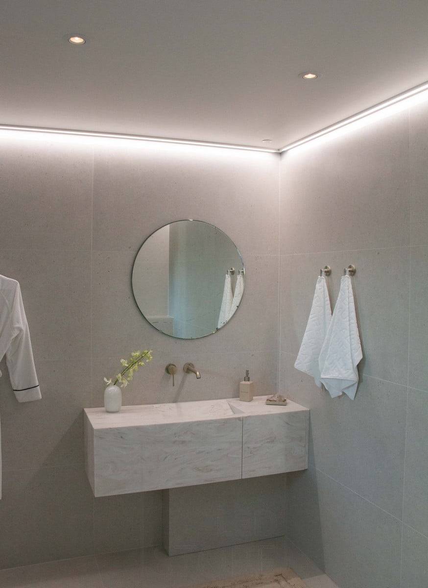 Salon de l'habitat 2022 : Bande LED montée sur une surface basse, au plafond près du mur, éclairant la salle de bain d'une lumière d'ambiance. Ledstore.fi
