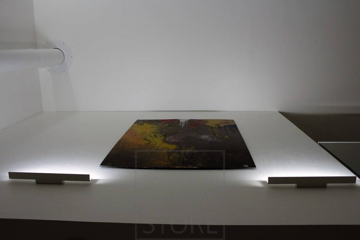Applique à lames éclairant de bas en haut et mettant en valeur l'oeuvre d'art par une lumière indirecte. Ledstore.fi