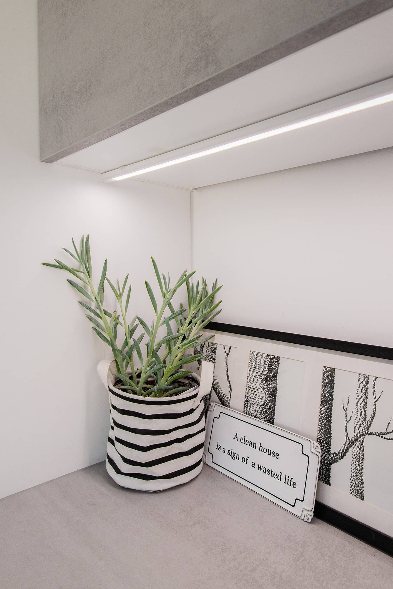 Dans une buanderie, une bande de LED montée sur un profilé de surface apporte un éclairage de travail au plan de travail. Ledstore.fi