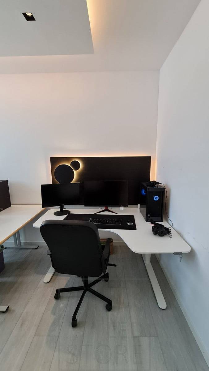 Luminaire décoratif ECLIPSE derrière l'ordinateur, disponible en deux tailles, créant un éclairage d'ambiance indirect. La température de couleur du luminaire est réglable, l'image montre la lumière avec une teinte chaude. Ledstore.fi