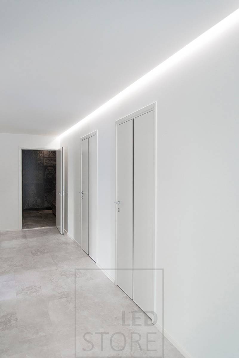 Bel éclairage d'un couloir en lumière indirecte, bande LED installée dans la rainure entre le plafond et le mur. Ledstore.fi