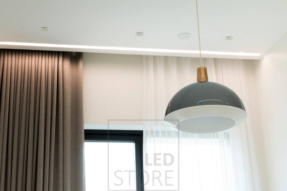 Dans la chambre à coucher, un large profilé encastré à côté des tringles à rideaux est équipé de bandes LED qui créent une lumière indirecte atmosphérique. Ledstore.fi