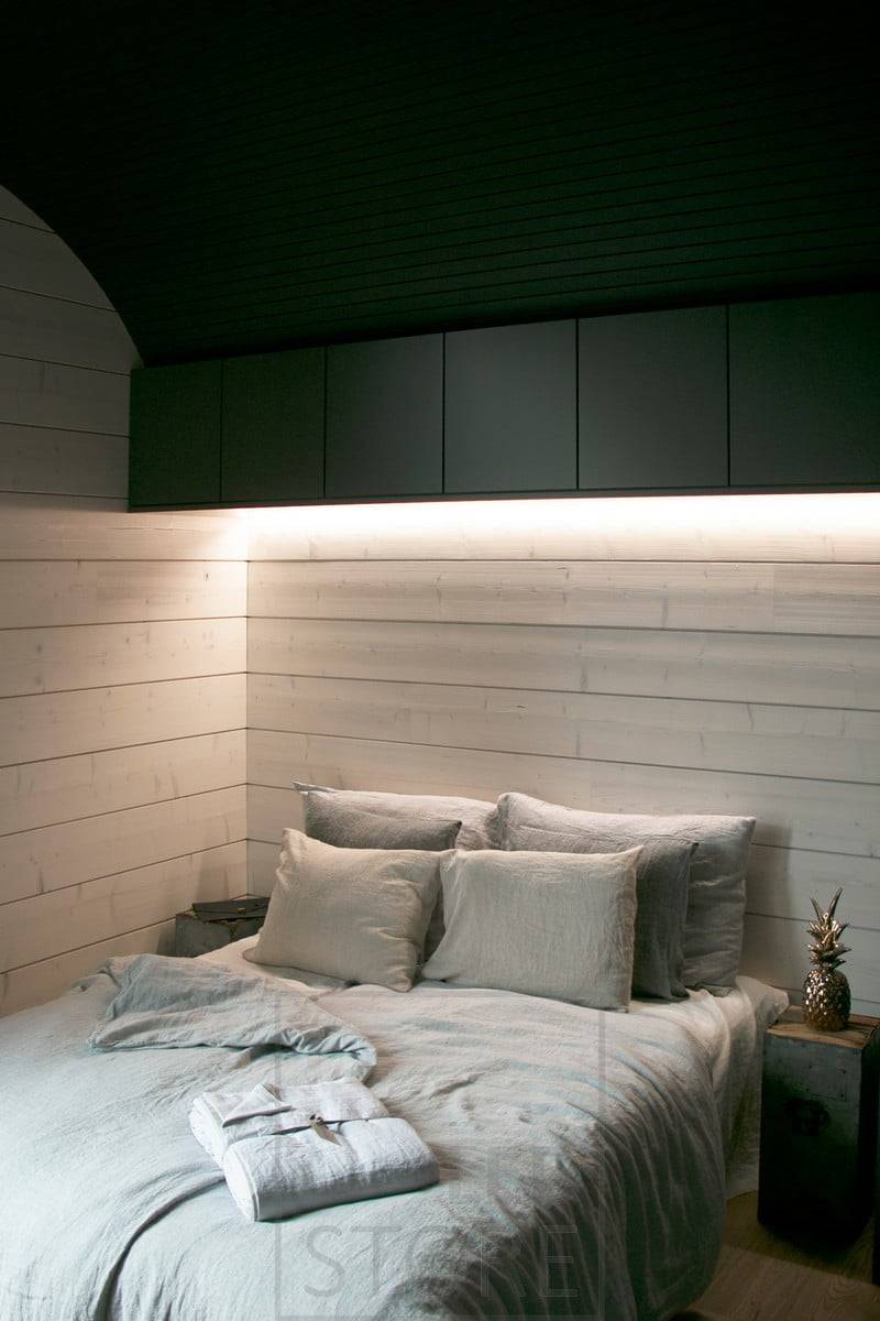 Des bandes LED fixées à la base des armoires murales fournissent un éclairage d'ambiance avec une lumière indirecte dans la chambre à coucher. Ledstore.fi