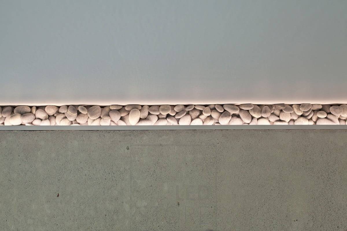 Un beau détail sur le sol mis en valeur par une bande LED. Lors du coulage du sol, un petit renfoncement a été laissé à côté du mur pour ajouter des pierres et un éclairage d'ambiance a été installé pour mettre en valeur les pierres. L'éclairage d'ambiance a été installé pour mettre en valeur les pierres. Il fonctionne également comme une veilleuse atmosphérique. Ledstore.fi