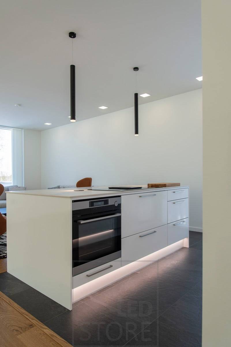 Un îlot avec un éclairage indirect dans le socle. L'îlot est également éclairé par les luminaires Piippu de LedStore. L'éclairage général est assuré par des luminaires à panneaux. Ledstore.fi