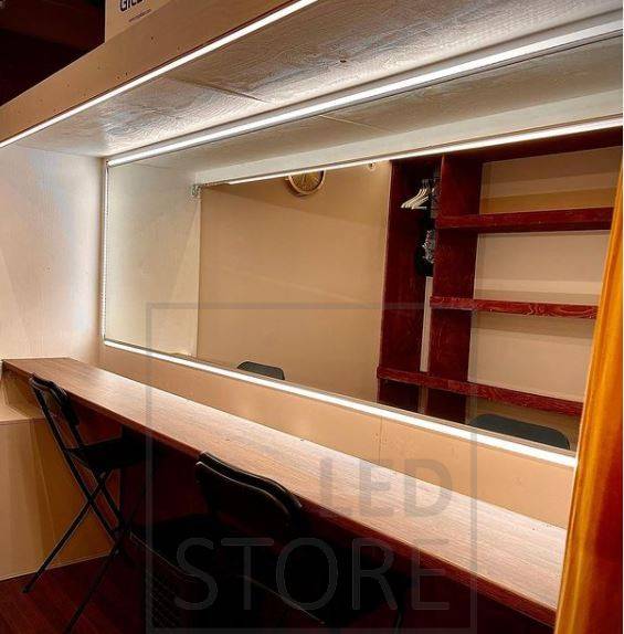 Salle de sport éclairée par des spots et une lumière indirecte d'ambiance. L'éclairage indirect est obtenu grâce à une bande lumineuse LED installée entre le plafond et le mur.
