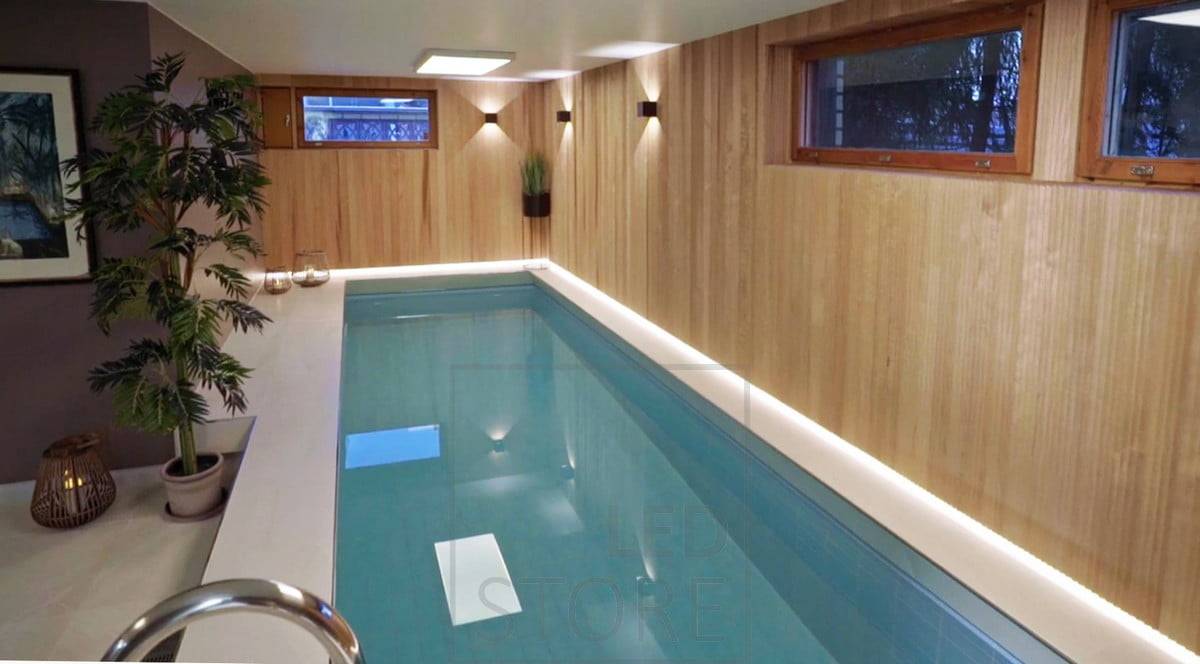 L'espace piscine est éclairé par des appliques FUNK noires et derrière le beau lambris, la bordure du sol est éclairée par une bande LED. Ledstore.fi