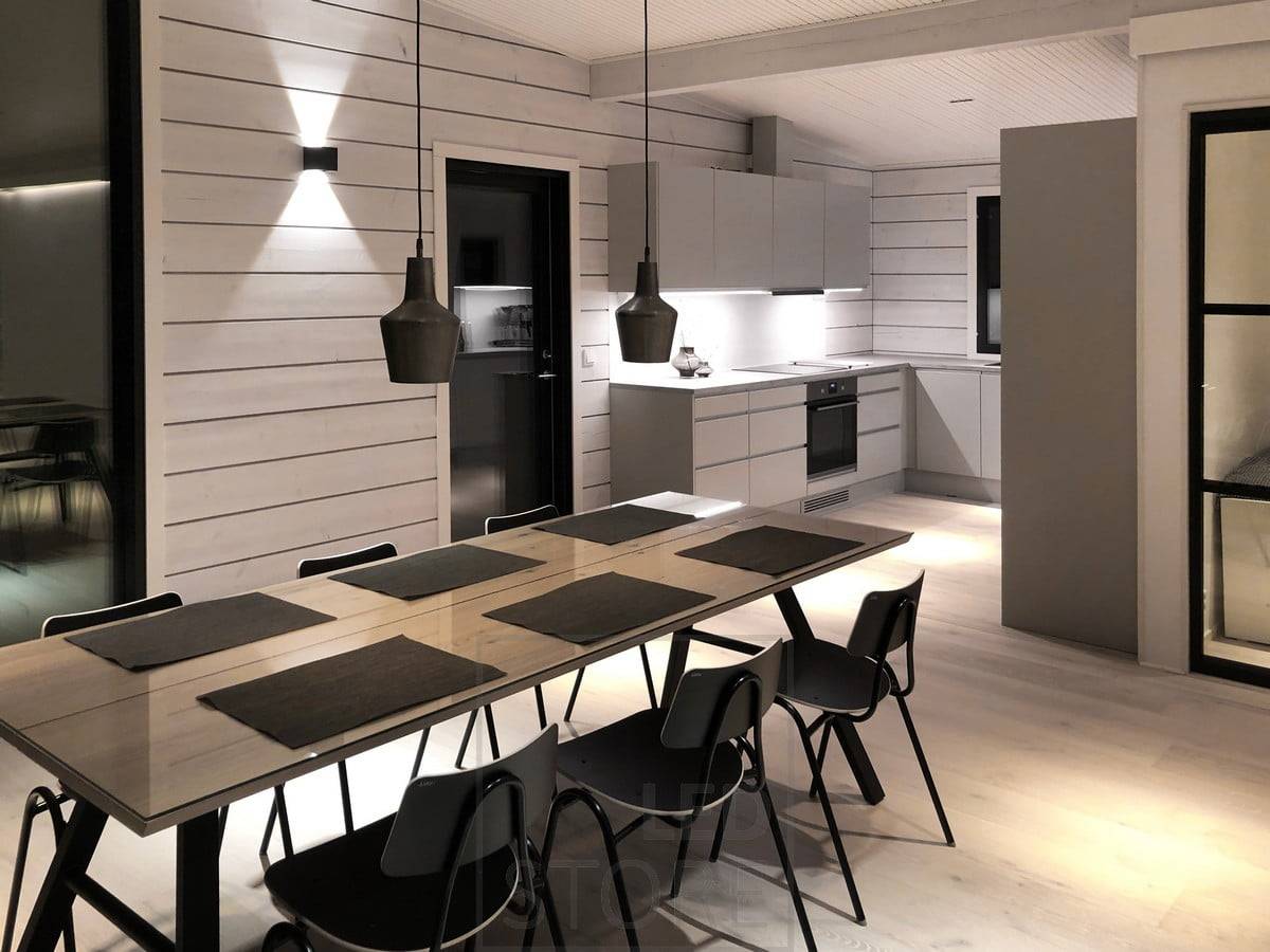 L'applique FUNK noire éclaire le salon et la salle à manger d'une lumière d'ambiance à travers le mur. Ledstore.fi