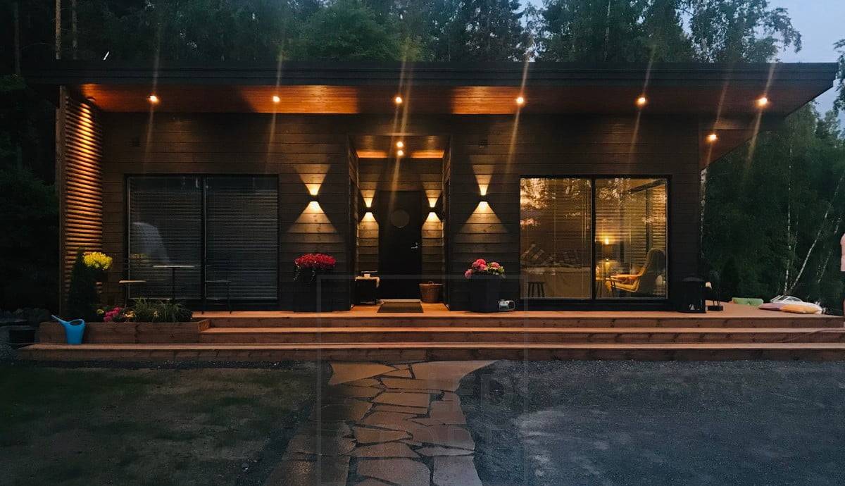 Les appliques FUNK noires sur le mur du bâtiment, illuminent la façade et créent un éclairage d'ambiance à l'extérieur. Les appliques FUNK ont un angle d'ouverture réglable en fonction de vos besoins. Le luminaire est également dimmable. Ledstore.fi