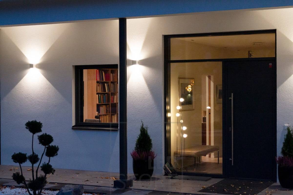 Appliques FUNK blanches sur le mur du bâtiment, éclairant la façade et créant un éclairage d'ambiance à l'extérieur. L'angle de la lumière est réglable. Ledstore.fi