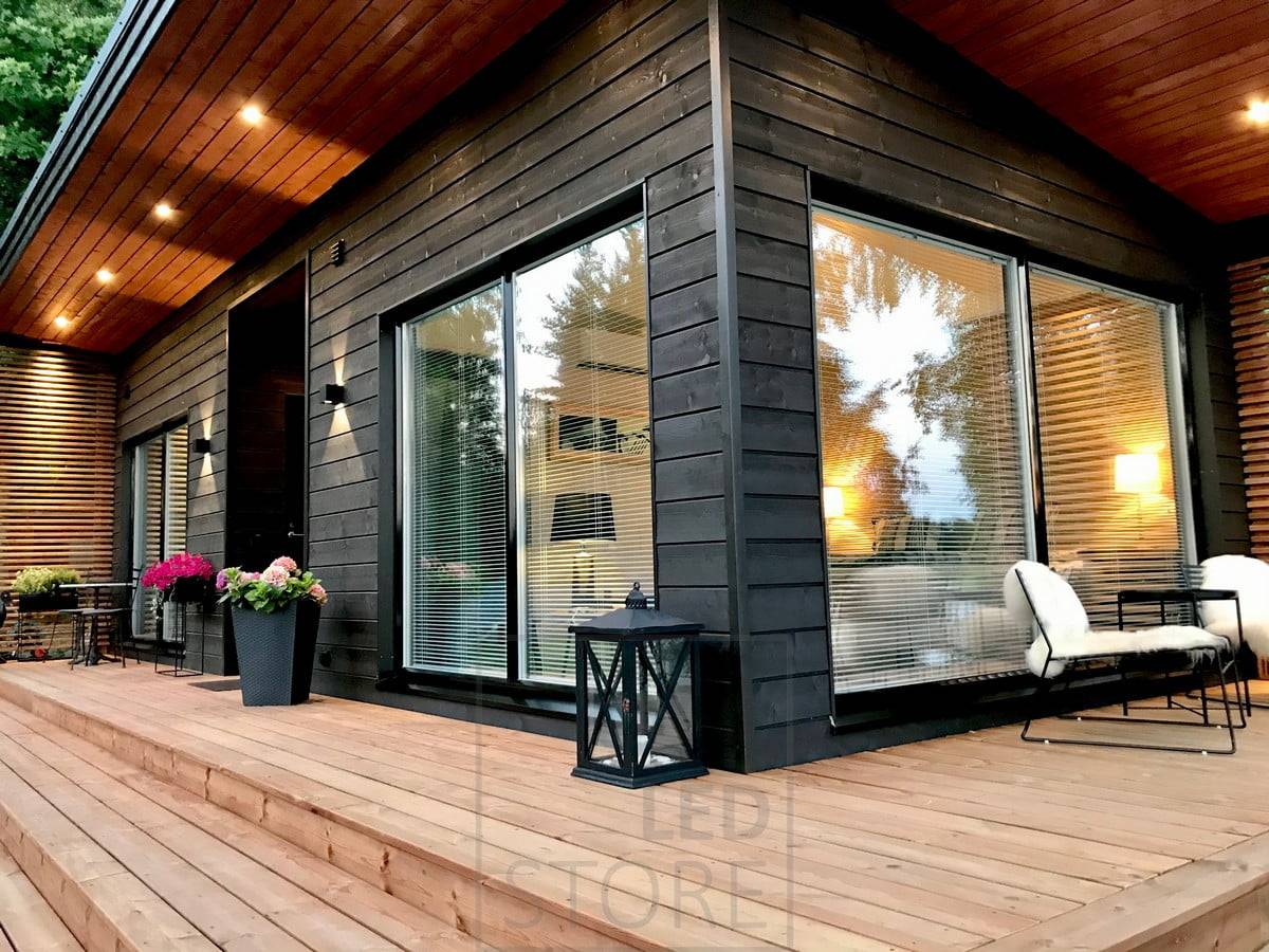 Appliques FUNK noires pour accentuer la façade du bâtiment et fournir une lumière indirecte. Spots KANTTI noirs sur le toit de la terrasse. Luminaires LINJA5 pour accentuer l'habillage. Ledstore.fi