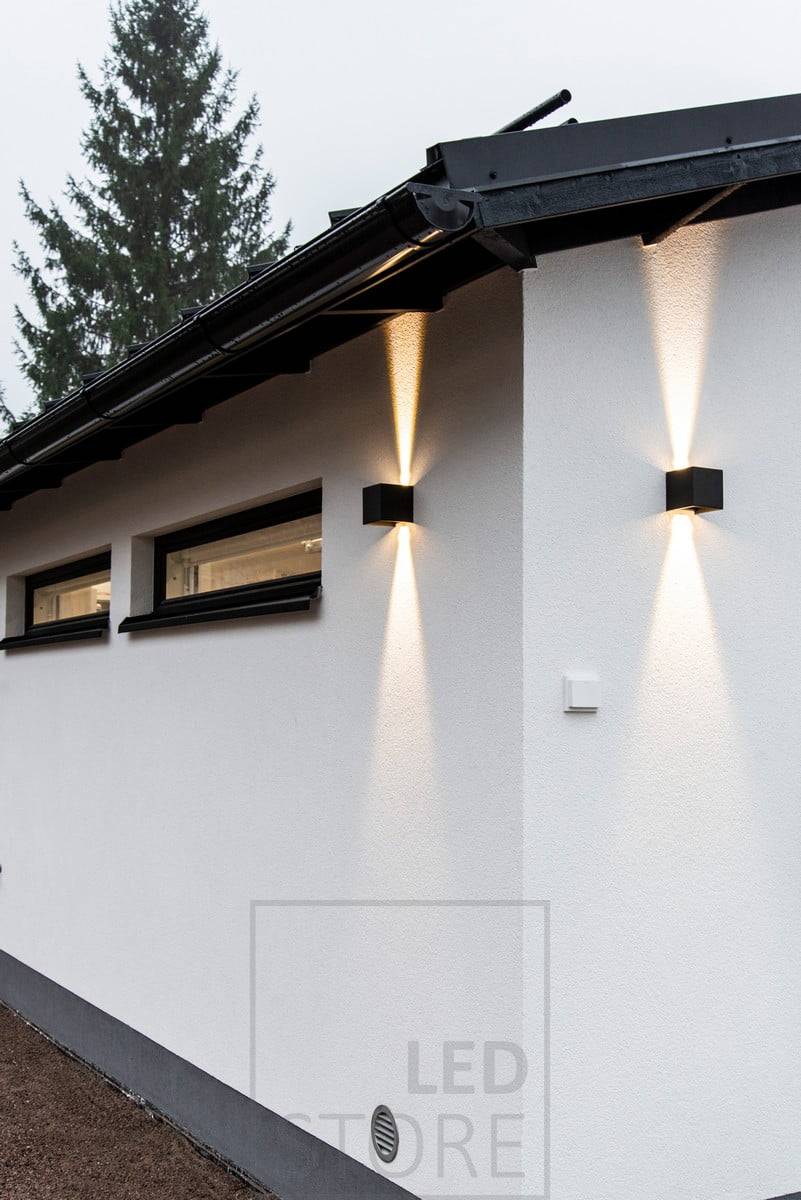 Appliques FUNK noires sur le mur du garage, éclairant vers le haut et vers le bas. Ledstore.fi