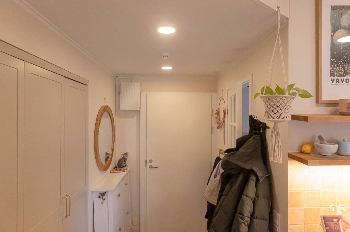 Deux panneaux LED ronds encastrés dans le plafond du couloir.