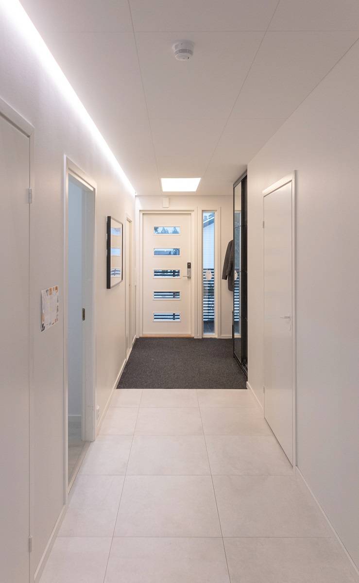 Bande LED au bord d'une rainure descendante dans un vestibule.