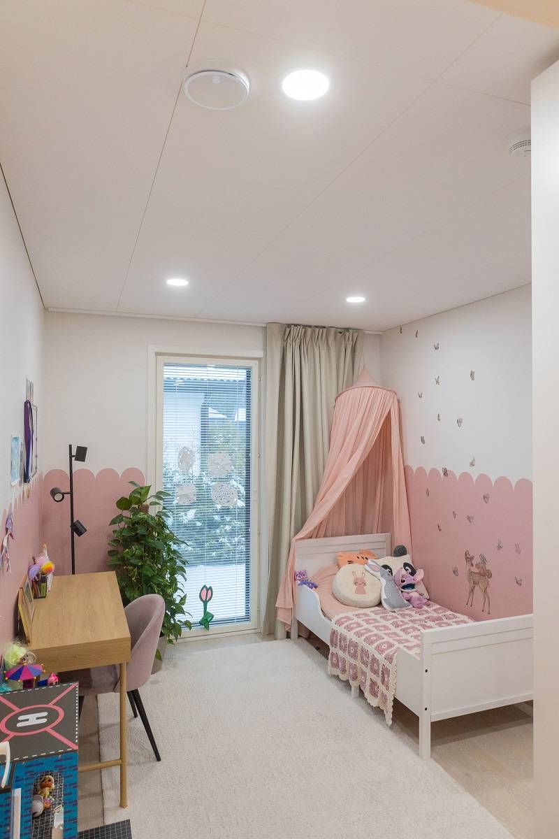 Panneaux LED ronds encastrés dans le plafond d'une chambre d'enfant.