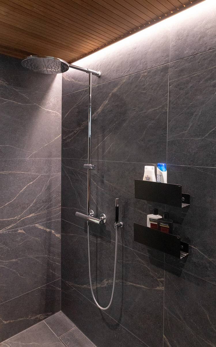 Salle de bain avec bande LED dans le renfoncement entre le mur et le plafond sur un bord.